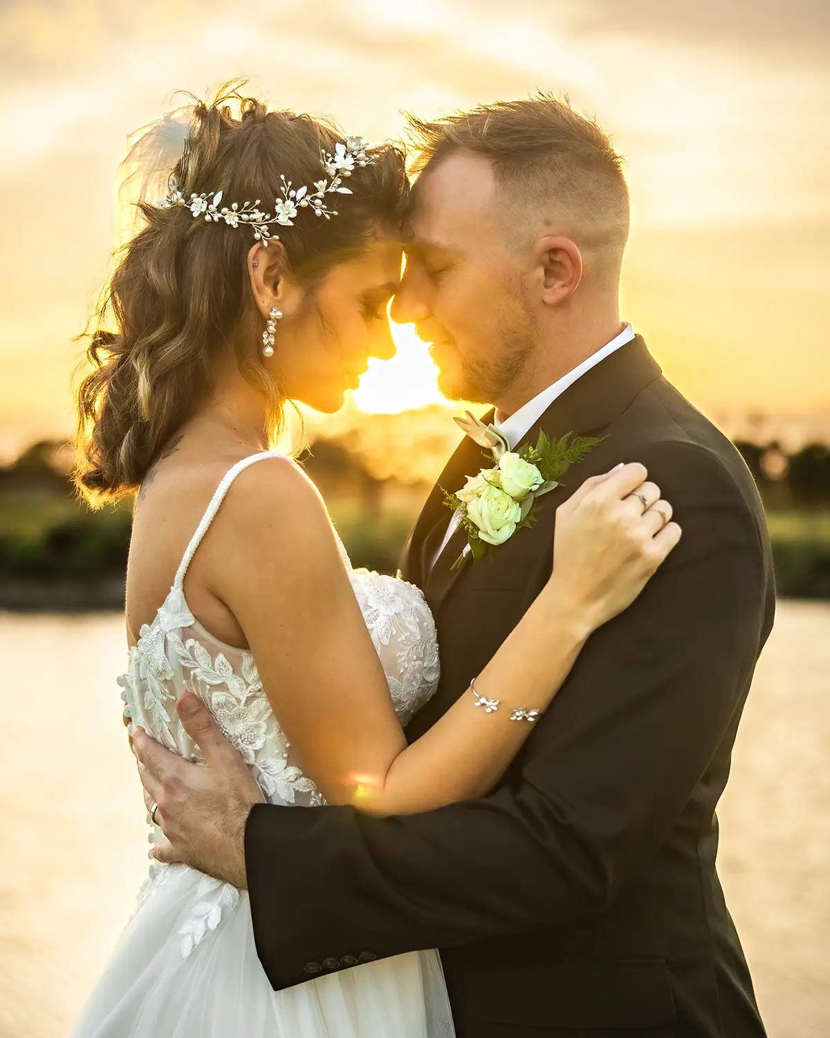 Bride and groom foreheads touching at golden hour